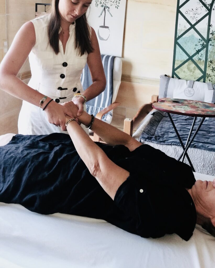 Une séance de kinésiologie avec le test arm reflex, allongé sur le dos la patiente allonge ses deux bras