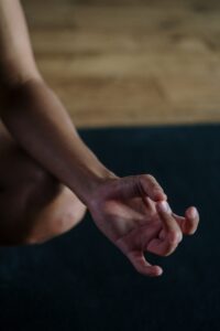 Focus sur une main faisant le symbole d'un mudra, pouce contre majeur