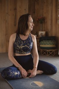 Yogi assise en posture du lotus regarde à l'extérieur avec un sourire dessiné sur son visage