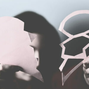 Une enfant déchire un cœur en papier, symbole d’une souffrance relationnelle dans une relation toxique.