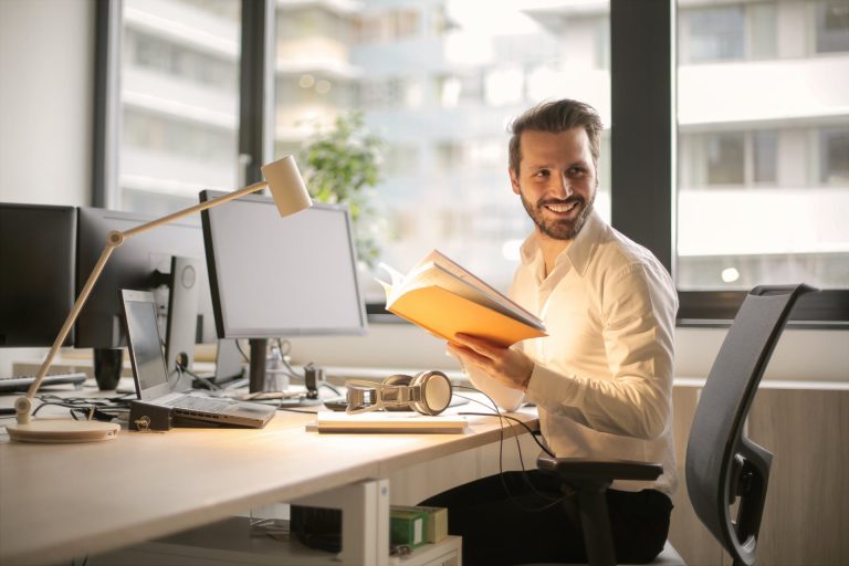 Un homme travaille efficacement devant son ordinateur avec entrain et avec le sourire