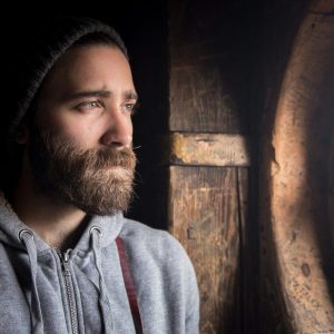 Les yeux remplis de tristesse et de chagrin un homme regarde à l'extérieur comme prisonnier de la situation