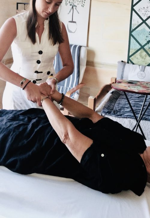 Une séance de kinésiologie avec le test arm reflex, allongé sur le dos la patiente allonge ses deux bras